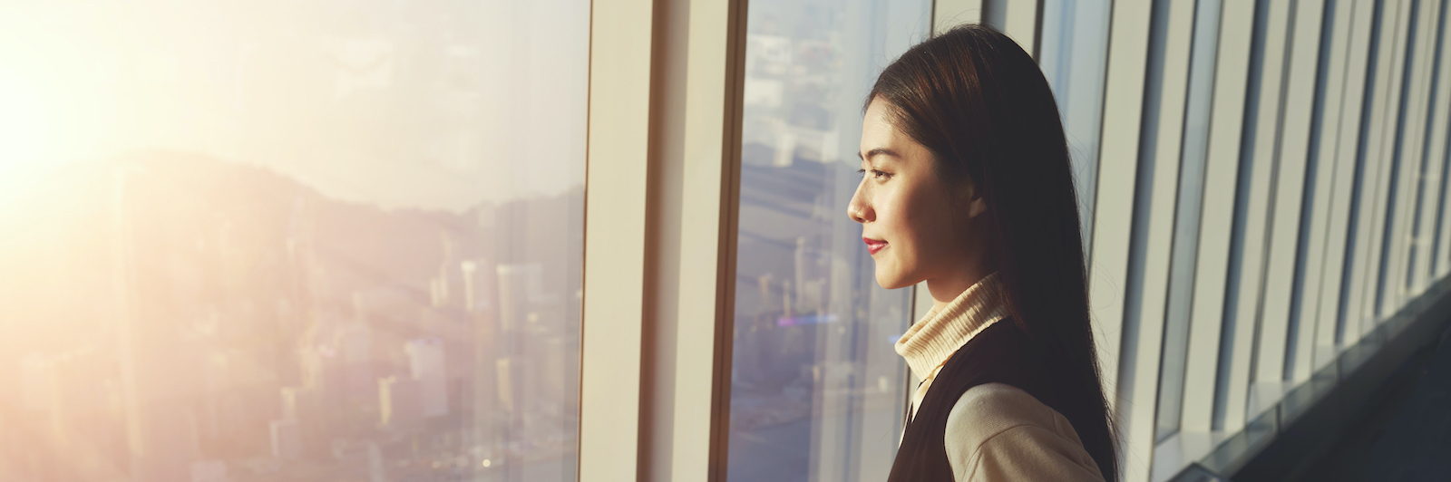 Woman gazing out of a high-rise building.